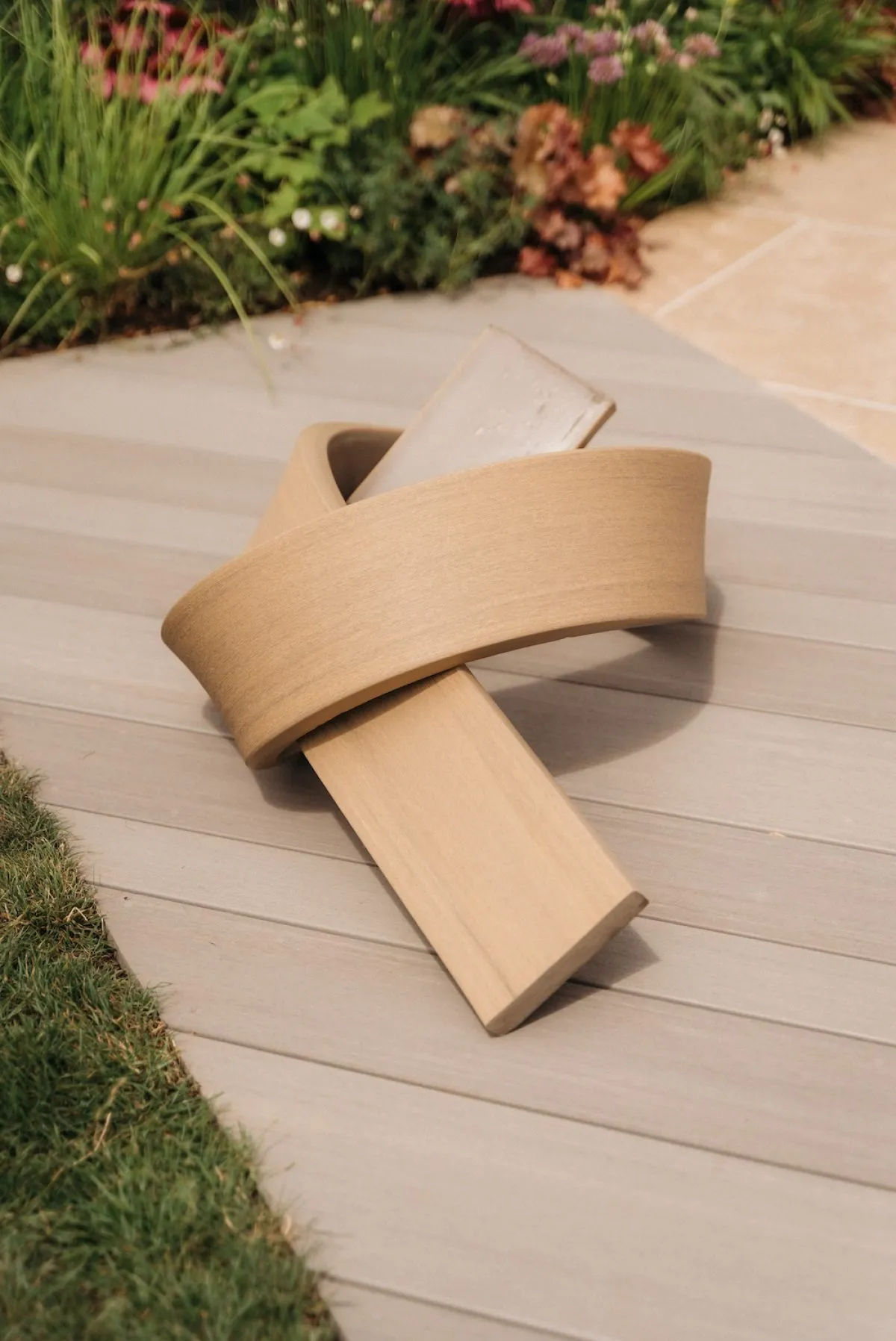 A piece of Elements decking tied in a knot, demonstrating the versatile nature of the boards